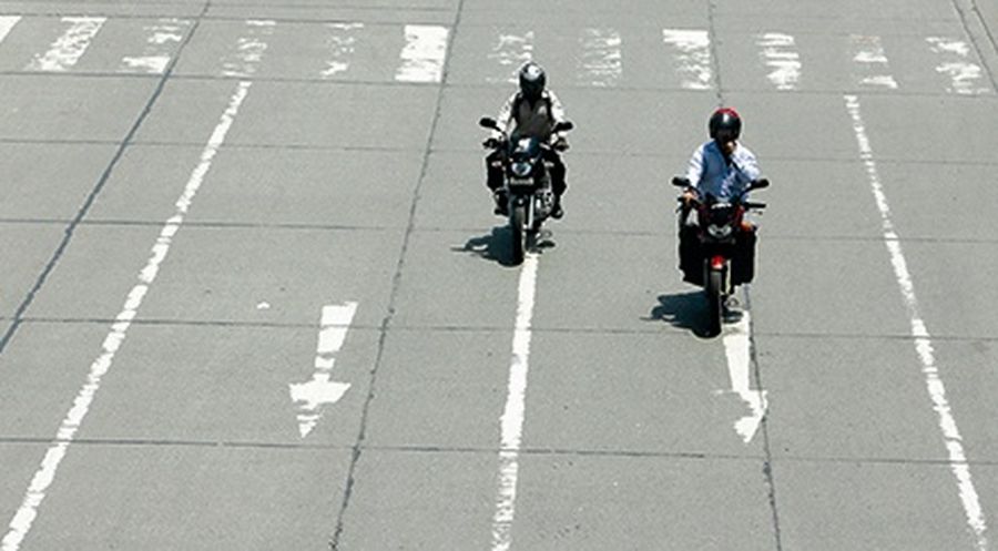 Motorbike riders drive on a road in Mumbai.