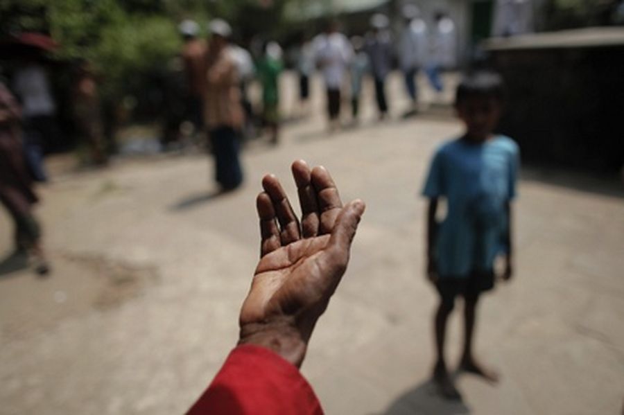 A Rohingya beggar reaches out his hand outside a mosque after Friday prayers in Sittwe. 