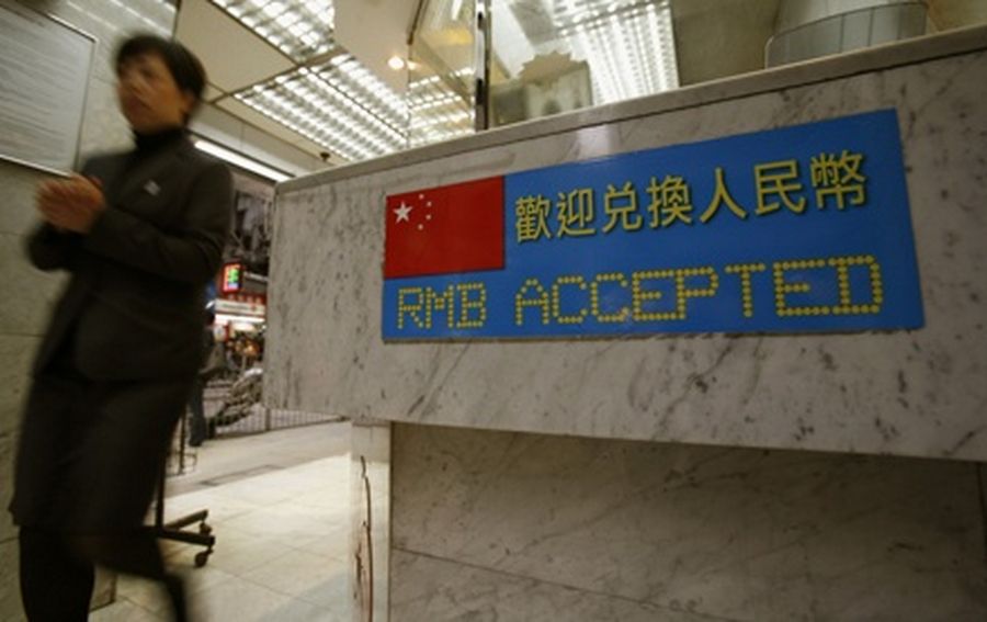 A woman walks past a foreign exchange store displaying a sign that it accepts the exchange of the renminbi in Hong Kong. 