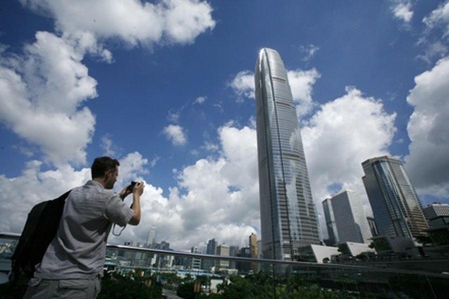 A visitor takes a picture in front of Two IFC, Hong Kong's highest commercial building, on a sunny day in the SAR’s business Central district. 