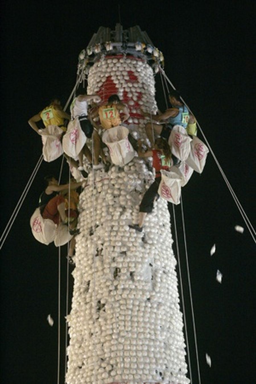 Climbers collect mock buns on a tower during a 'bun-scrambling' event as part of the Bun Festival on the tiny island of Cheung Chau in Hong Kong.