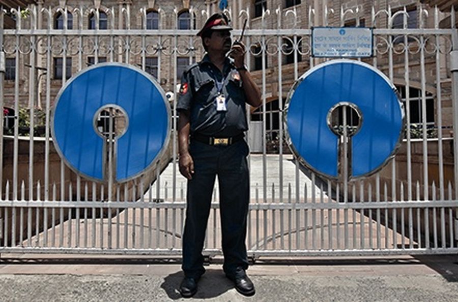 A security personnel stands guard in front of the gate of the State Bank of India regional office in Kolkata.