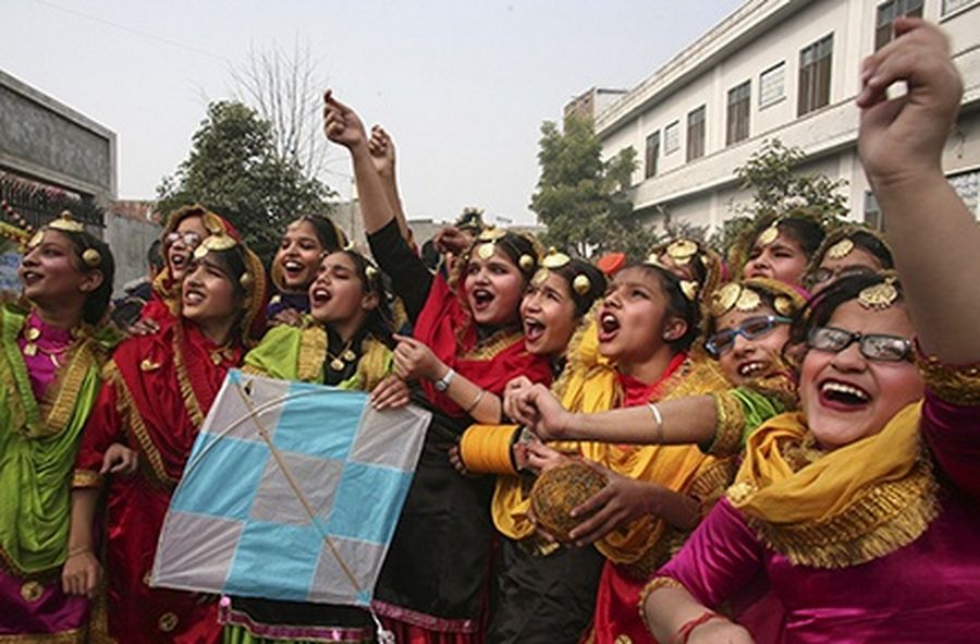 Schoolgirls wearing colourful dresses cheer as they fly a kite during the Lohri festival celebrations at their school in the northern Indian city of Amritsar.