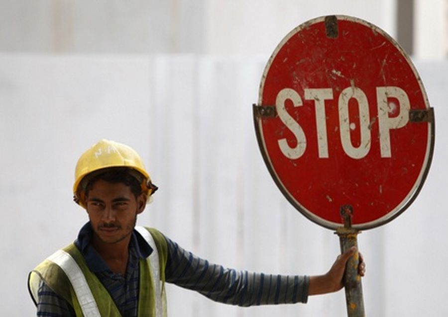 A foreign worker directs traffic along a busy construction site in Singapore. 