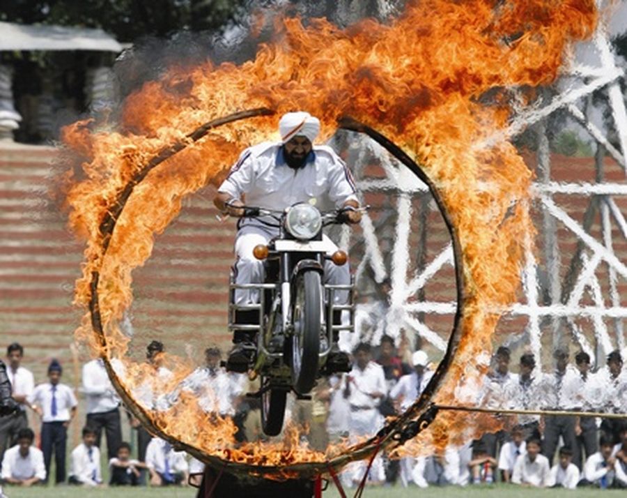 A motorcyclist from the Kashmir Police rides through a ring of fire during Independence Day celebrations in Srinagar. 