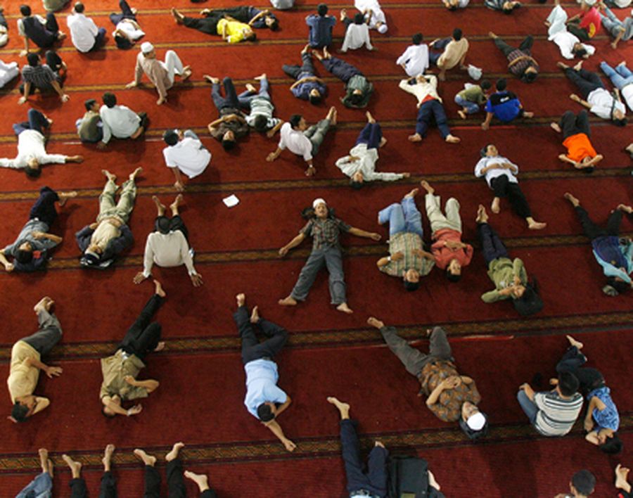 People take naps at the Istiqlal Mosque after attending Friday prayers in Jakarta
