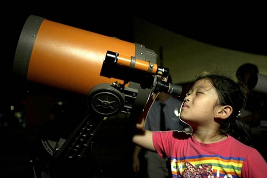 A girl takes a closer view of the planet Mars through a telescope at the Hong Kong Space Museum. 