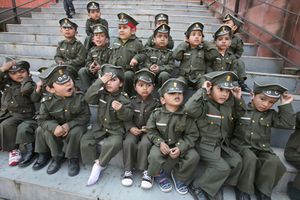 School children dressed as military soldiers sit in Chandigarh