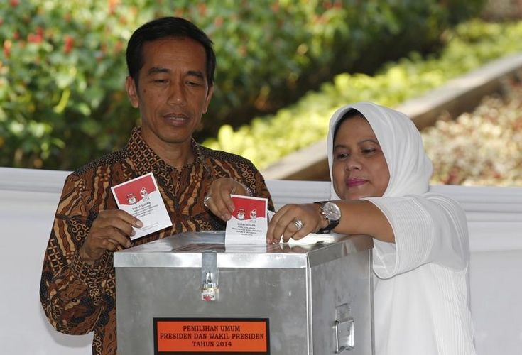 Indonesian presidential candidate Joko "Jokowi" Widodo and his wife Iriana cast their vote in Jakarta July 9, 2014. 