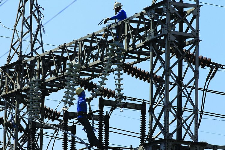 REUTERS/Romeo - Workers work on a transmission station of National Power Corporation