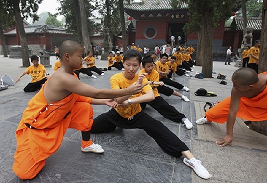 A Shaolin student guides a Swiss girl of Chinese origin during a campaign to promote kung fu at the Shaolin Temple in Dengfeng, Henan Province.