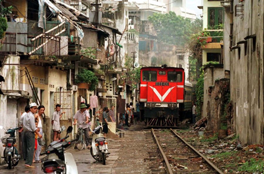 A train makes its way down a narrow alley in Hanoi. The ADB is scaling up its investments in rail an