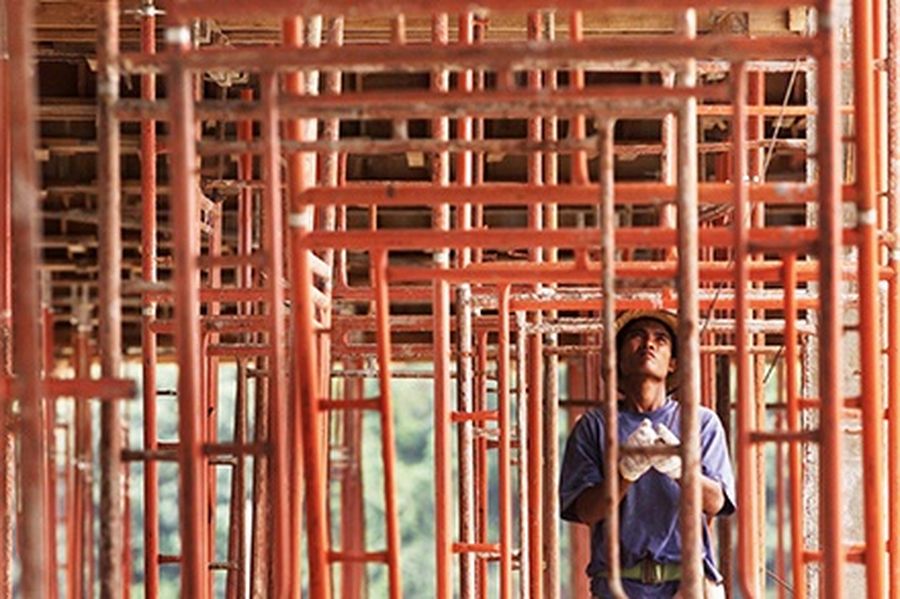 A worker prepares scaffolding at a construction site in Kuala Lumpur.
