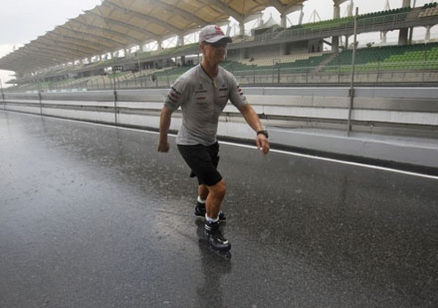 Mercedes Formula One driver Michael Schumacher of Germany roller blades down the track in the rain ahead of the Malaysian F1 Grand Prix at the Sepang circuit. 