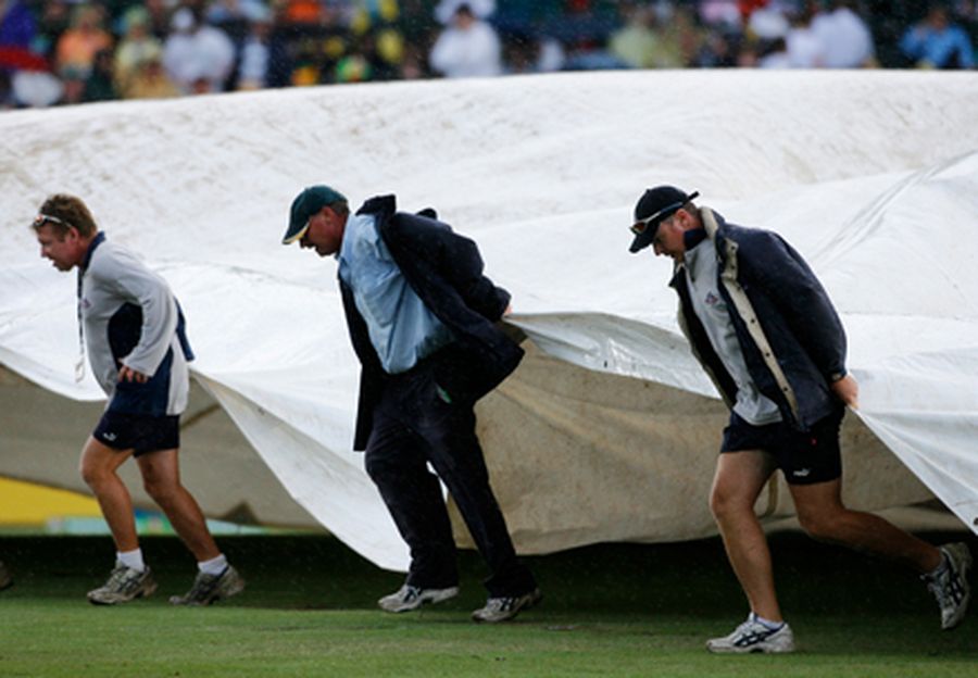Groundsmen pull covers over the pitch as rain falls during the second one-day international tri-seri