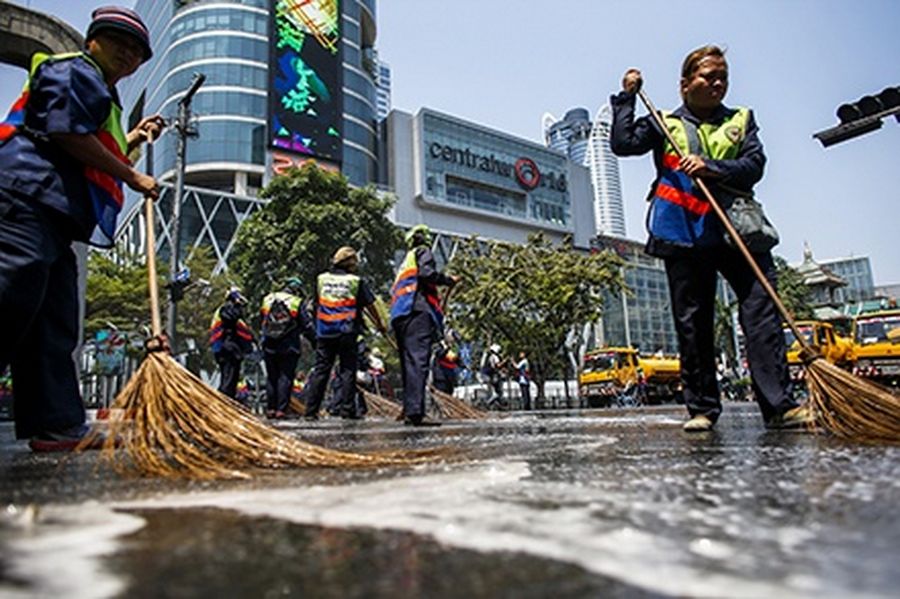City workers clean a street in front of a shopping centre as anti-government protesters decamped from protest sites around the capital and regrouped in central Lumpini Park in Bangkok.