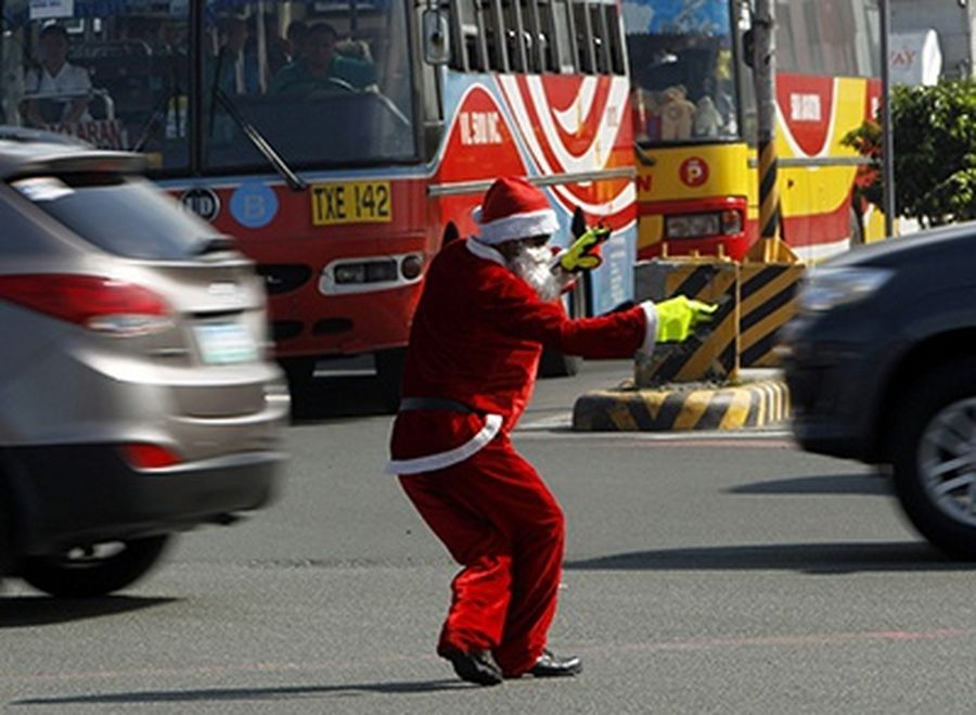 Ramiro Hinojas, 47, a traffic enforcer, wears a Santa Claus costume as he directs traffic along a main street in Pasay city, metro Manila.