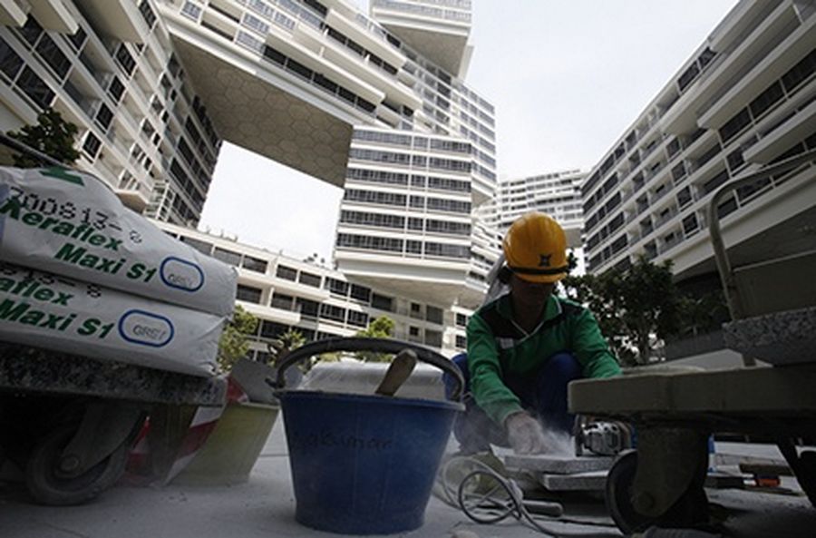 A worker cuts tiles as he works on finishing touches of the common area of a newly completed condominium project in Singapore.