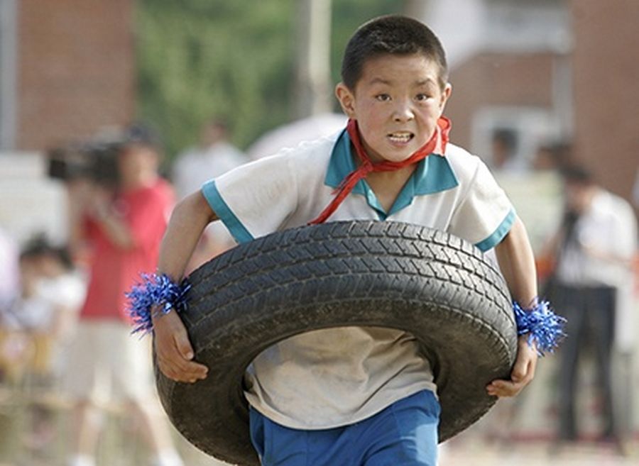 A student holding a tyre takes part in an event at an Olympic education model school in Miyun County of Beijing.