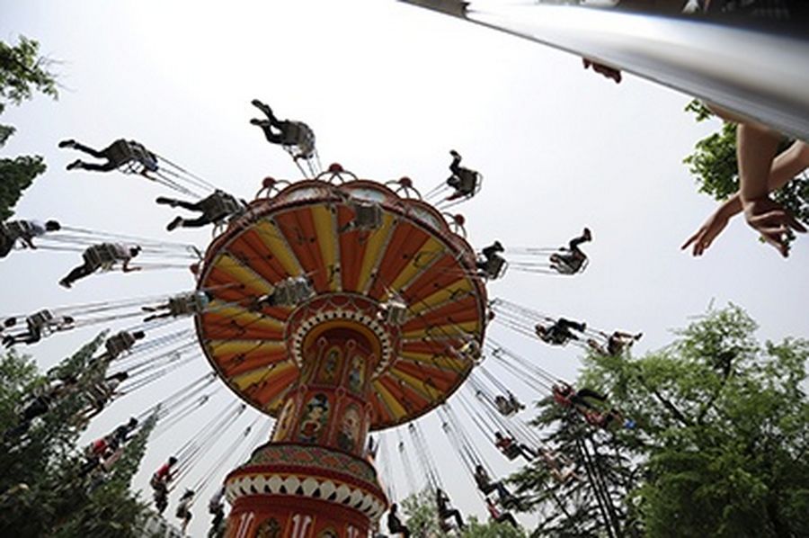 People ride on a chair-o-plane at a park on May Day holiday in Hefei, Anhui province.