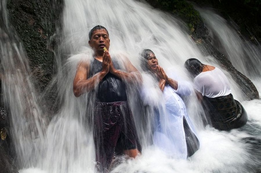 Balinese Hindu devotees bathe in the Sebatu waterfall during a “Melukat” purification ritual in Gianyar District in the Indonesian island of Bali.