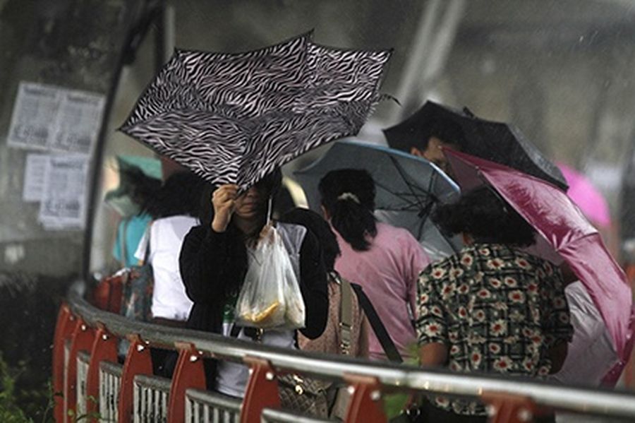 A woman holds an umbrella as she walks during heavy rain in Bangkok.