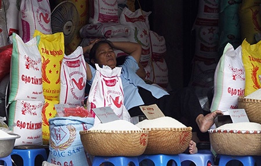 A rice seller takes a rest as she waits for customers at a market in Hanoi.