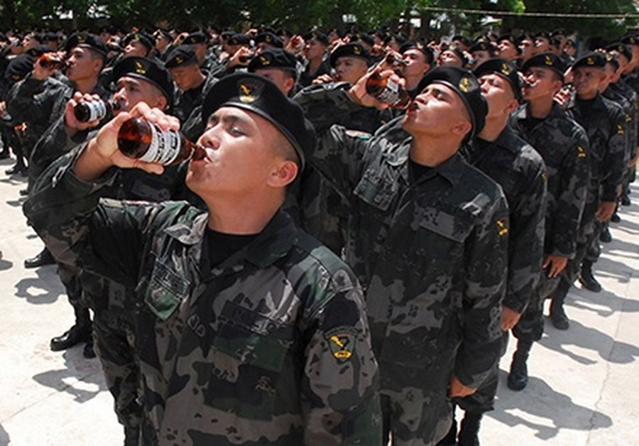 Members of the Philippine National Police Regional Mobile Group drink beer during a traditional ceremonial toast after their graduation from the “Internal Security Operations Course”, at a police training camp in Sibong.